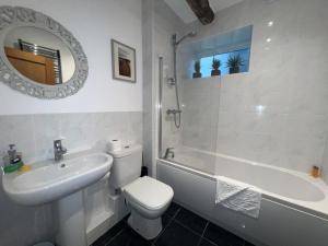 a bathroom with a sink and a toilet and a bath tub at Spring Cottage in Ulverston