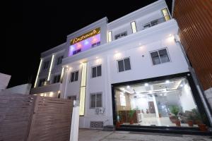 un edificio bianco con un cartello sopra la notte di Raghavam Hotel by Stay Bliss Retreats a Ayodhya