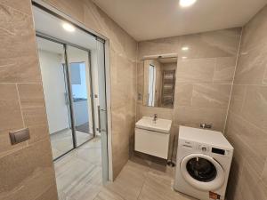 ein Badezimmer mit Waschmaschine und Waschbecken in der Unterkunft NEW Apartment - O2 Arena Prague with parking in Prag