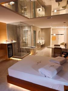 a bedroom with a large white bed and a bathroom at Motel Decameron (Adults Only) in Salvador