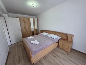 a bedroom with a bed with two towels on it at Milan Luxury Apartaments XVIII in Târgu-Mureş