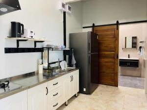 a kitchen with a stainless steel refrigerator and a door at I Rak Ta-lay House in Sam Roi Yot
