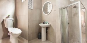Un baño con inodoro, lavabo y ducha. en Matusadona Suites, en Mokopane 9 fotos más