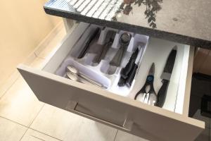 un cajón con tijeras y otros utensilios de cocina en Matusadona Suites, en Mokopane