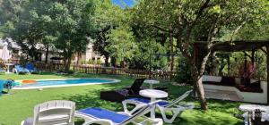 a yard with lawn chairs and a swimming pool at Cal Mosqueta in Sant Llorenç de Morunys