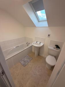 a bathroom with a toilet and a sink and a skylight at ResiLets - Berwick House - Large 4 Bed Townhouse - Contractor stays in Cowpen