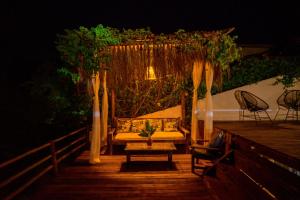 a gazebo with a couch on a deck at night at Recanto do Villa 1 in Trancoso