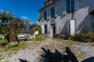 a house with a bench and an umbrella in the yard at Etape en Barétous - 12 personnes in Aramits +12 photos