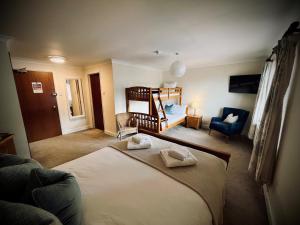 un dormitorio con una cama y un dormitorio con una cuna en The Crown Inn, en Rodmarton