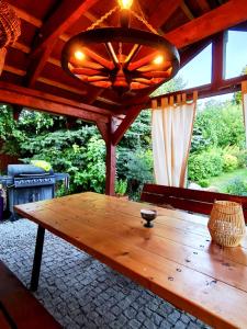 a wooden table in a pavilion with a chandelier at Przystanek Spokój - Nowe Siodło Sudety Środkowe in Nowe Siodło