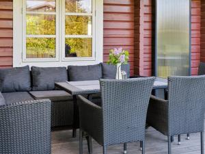 eine Außenterrasse mit einem Tisch und Stühlen in der Unterkunft Holiday Home Swartebrand - 450m from the sea by Interhome in Neder Lysabild