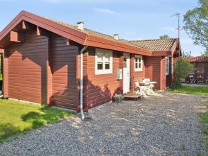 eine Holzhütte mit einem Picknicktisch davor in der Unterkunft Holiday Home Swartebrand - 450m from the sea by Interhome in Neder Lysabild