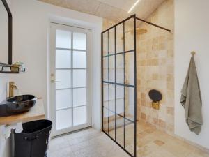 a bathroom with a glass shower door and a sink at Holiday Home Kerkko - 150m from the sea by Interhome in Skovmose +15 photos