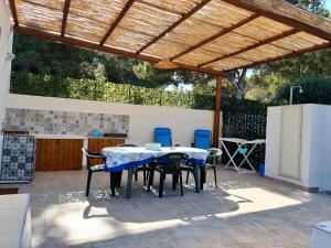 een patio met een tafel en stoelen onder een houten pergola bij Villa Debora Favignana (TP) in Favignana +25 foto's