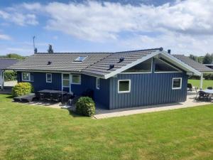 a blue house with a patio in a yard at Holiday Home Toja - 700m from the sea by Interhome in Neder Lysabild