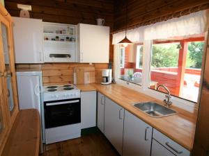 a kitchen with white cabinets and a stove and a sink at Holiday Home Byrge - 2km from the sea by Interhome in Fanø