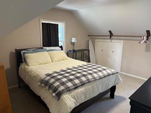 a bedroom with a bed with a checkered blanket at Old Orchard Kirtland, Ohio 