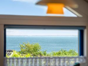 a view of the ocean through a window at Holiday Home Odin - 200m from the sea by Interhome in Mommark +22 photos