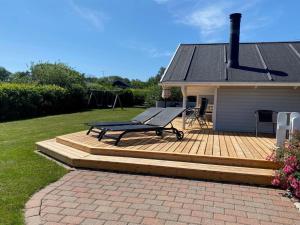 a wooden deck with a bench on top of a house at Holiday Home Odin - 200m from the sea by Interhome in Mommark