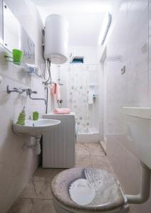 a white bathroom with a toilet and a sink at Apartment J&I in Split