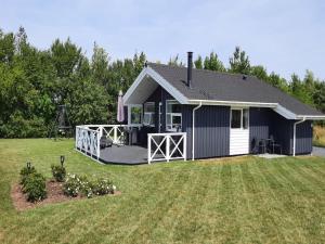 a small blue and white house with a yard at Holiday Home Gustava - 700m from the sea by Interhome in Neder Lysabild