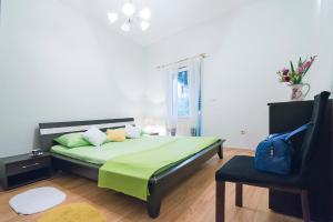 a bedroom with a bed with green sheets and a chair at Apartment J&I in Split
