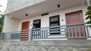 a house with three doors and a balcony at Uno's Krib - Pilar in Pilar