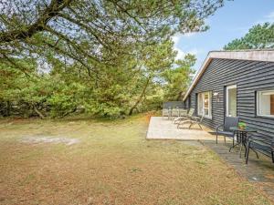 a house with a patio with chairs and a table at Holiday Home Samuli - 400m from the sea by Interhome in Fanø