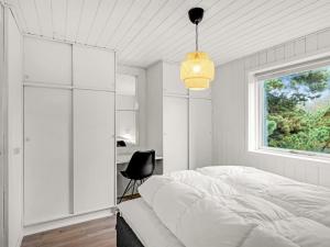 ein weißes Schlafzimmer mit einem Bett und einem Fenster in der Unterkunft Holiday Home Samuli - 400m from the sea by Interhome in Fanø
