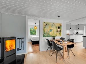 eine Küche und ein Esszimmer mit einem Tisch und einem Kamin in der Unterkunft Holiday Home Samuli - 400m from the sea by Interhome in Fanø