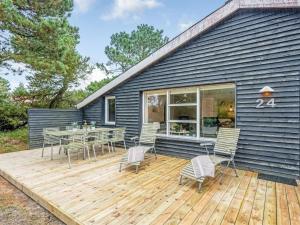 eine Holzterrasse mit einem Tisch und Stühlen auf einem Haus in der Unterkunft Holiday Home Samuli - 400m from the sea by Interhome in Fanø + 16 Fotos