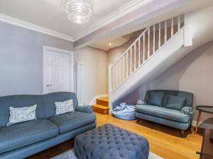 a living room with a couch and a stair case at Star Of The Sea in Broadstairs