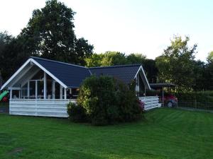 a white house with a black roof and a yard at Holiday Home Aulis - 230m from the sea by Interhome in Sarup