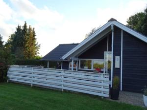 a house with a white fence in front of it at Holiday Home Aulis - 230m from the sea by Interhome in Sarup