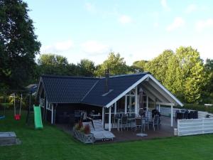 a house with a deck with chairs and tables at Holiday Home Aulis - 230m from the sea by Interhome in Sarup +23 photos