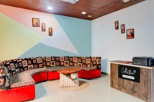 a room with a red couch and a table at Collection O Malavli Lonavala Hill View in Lonavala