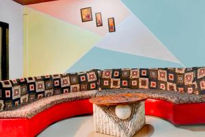 a red couch with a table in a room at Collection O Malavli Lonavala Hill View in Lonavala