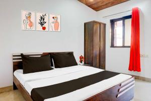 a bedroom with a large bed with a red curtain at Collection O Malavli Lonavala Hill View in Lonavala +28 photos