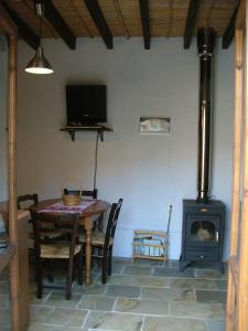 uma sala de jantar com uma mesa e um fogão a lenha em ANOI 1-bedroom country House em Episkopi Pafou