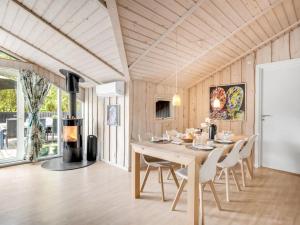 Un comedor con mesa y sillas y chimenea. en Holiday Home Impi - 1-5km from the sea by Interhome, en Fanø