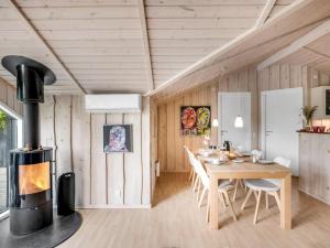 comedor con estufa de leña y mesa en Holiday Home Impi - 1-5km from the sea by Interhome, en Fanø
