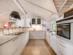 cocina con armarios blancos y techo de madera en Holiday Home Impi - 1-5km from the sea by Interhome, en Fanø 22 fotos más