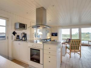 a kitchen with a stove top oven next to a living room at Holiday Home Eikka - 600m from the sea by Interhome in Fanø