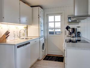 a white kitchen with a sink and a dishwasher at Holiday Home Eikka - 600m from the sea by Interhome in Fanø +7 photos