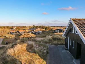 a house on the side of a field with houses at Holiday Home Hansina - 500m from the sea by Interhome in Fanø