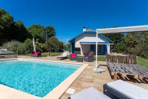a swimming pool with a bench and an umbrella at L'Azuré de Monein in Monein