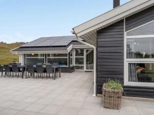 eine Terrasse mit Tisch und Stühlen und ein Gebäude in der Unterkunft Holiday Home Alli - 800m from the sea by Interhome in Fanø