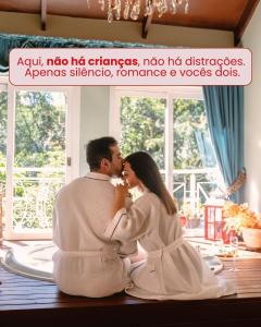 a man and a woman sitting on a table kissing at Le Boutique Hotel Gramado - Exclusivo para Casais in Gramado