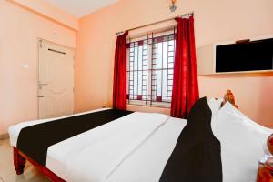 TallākulamCollection O Anna Nagar Madurai的一间卧室配有一张带红色窗帘的床和一扇窗户
