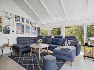 Una sala de estar con sofás azules y una mesa. en Holiday Home Julie - 1-5km from the sea by Interhome, en Fanø